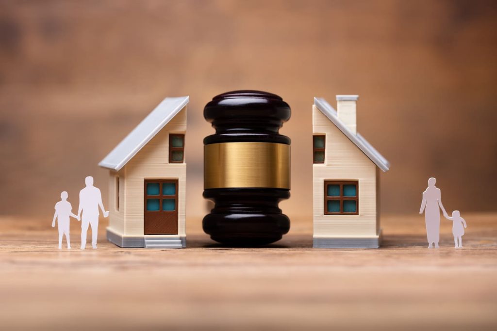 A house split by a gavel with a man and son on the left, and a mother and daughter on the right, symbolizing a divorce in Winston-Salem.