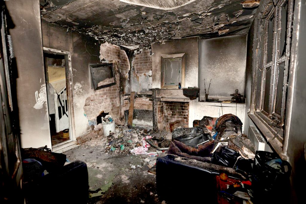 A fire-damaged house in High Point with burned interior items and visible damage.
