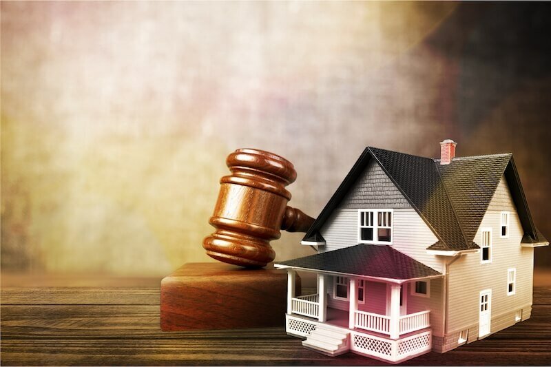 A miniature house with a gavel, symbolizing tax lien issues on a Midland home.