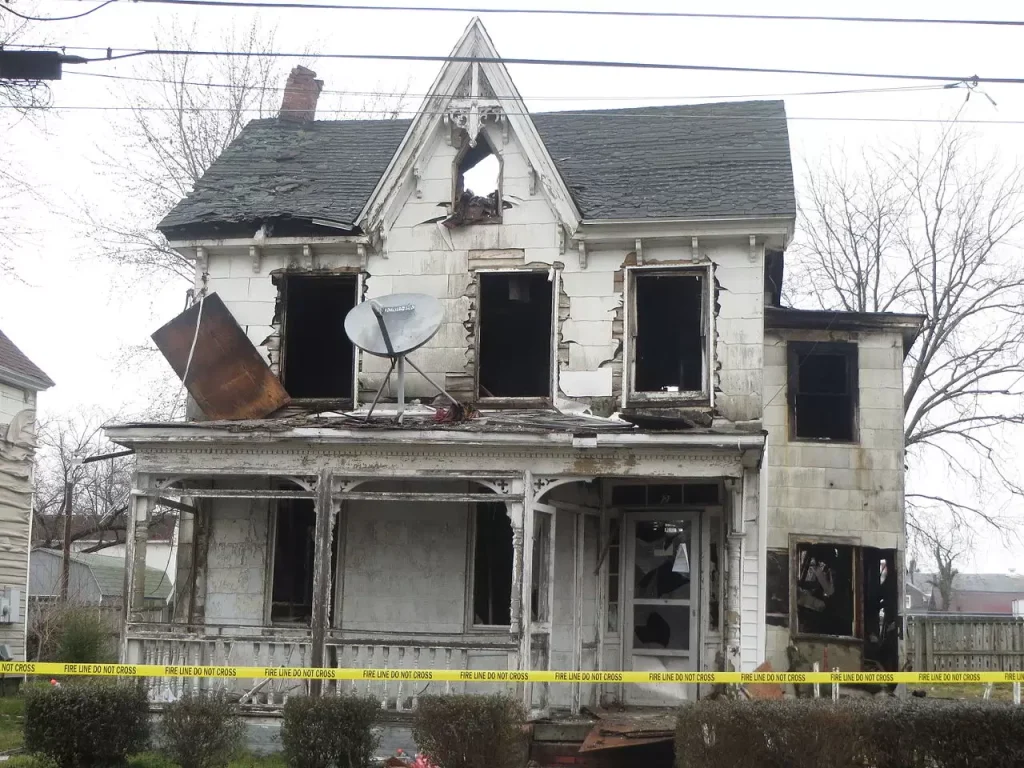 A fire-damaged house in Burlington showing visible burn marks and structural damage.