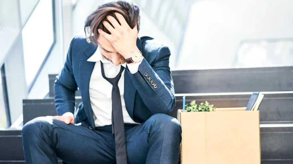 A man holding his head, looking stressed and problematic.